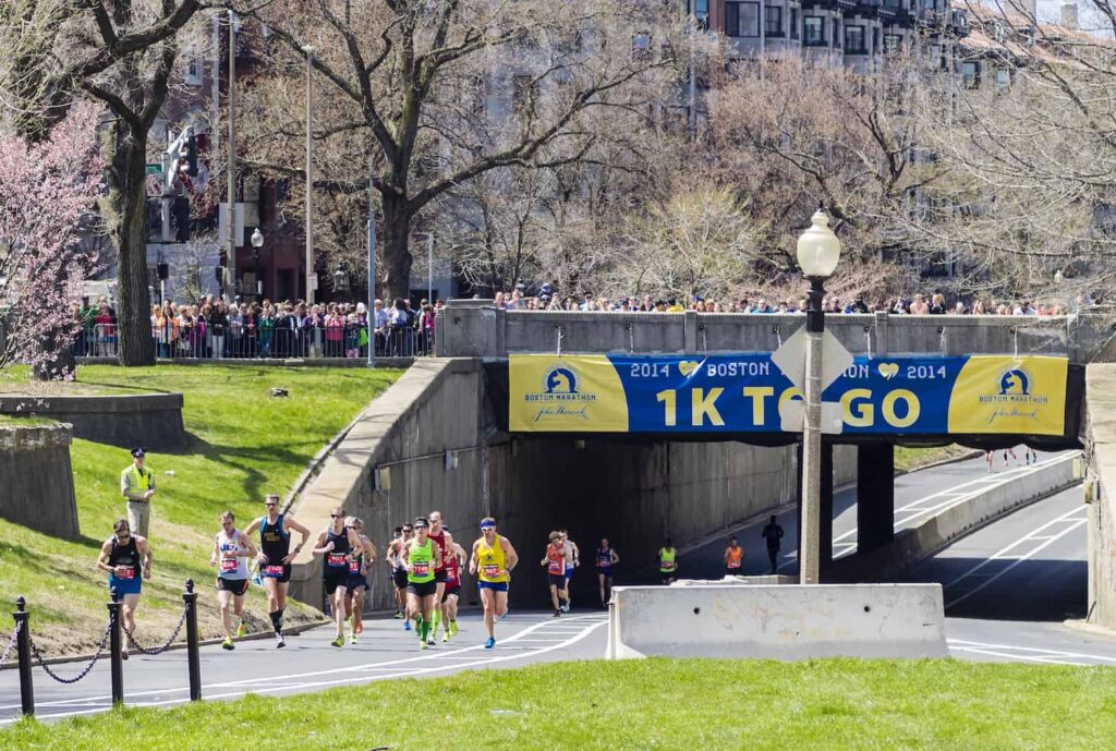 runners qui passent sous un pont au marathon de Boston près de l'arrivée
