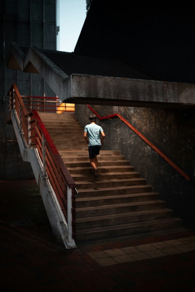 coureur qui monte des escaliers lors d'une séance de running la nuit en ville