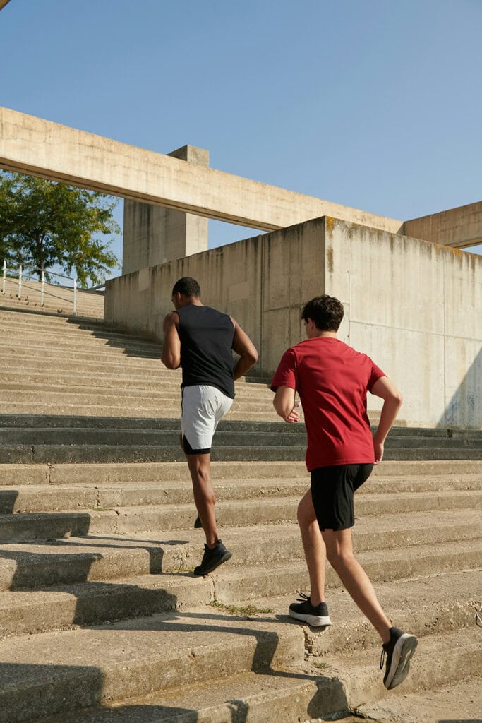 deux coureurs masculins courant dans les escaliers de la ville