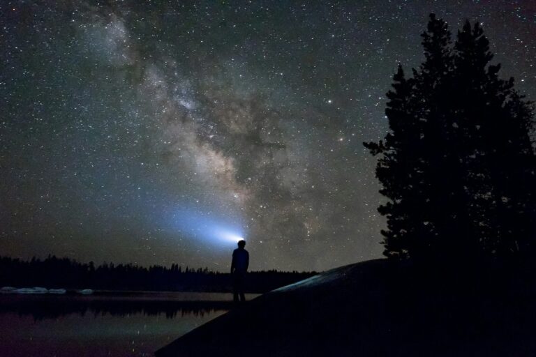 traileur de nuit avec lampe frontale au milieu des étoiles
