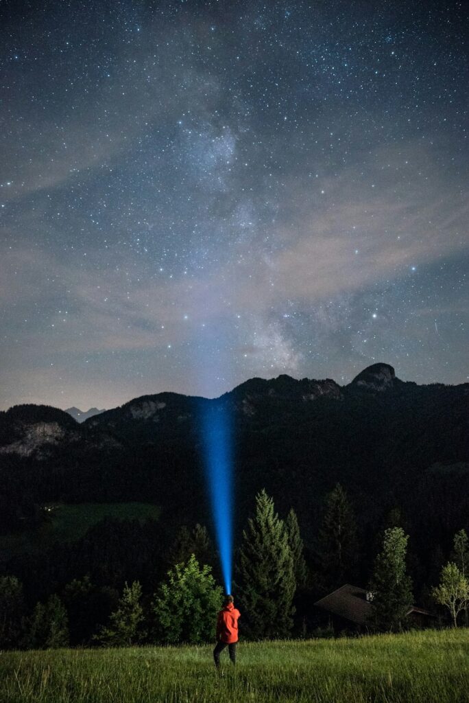 traileur avec sa lampe frontale sur un sentier la nuit