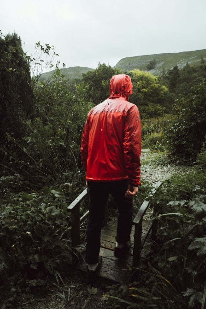 randonneur avec veste waterproof sous pluie battante